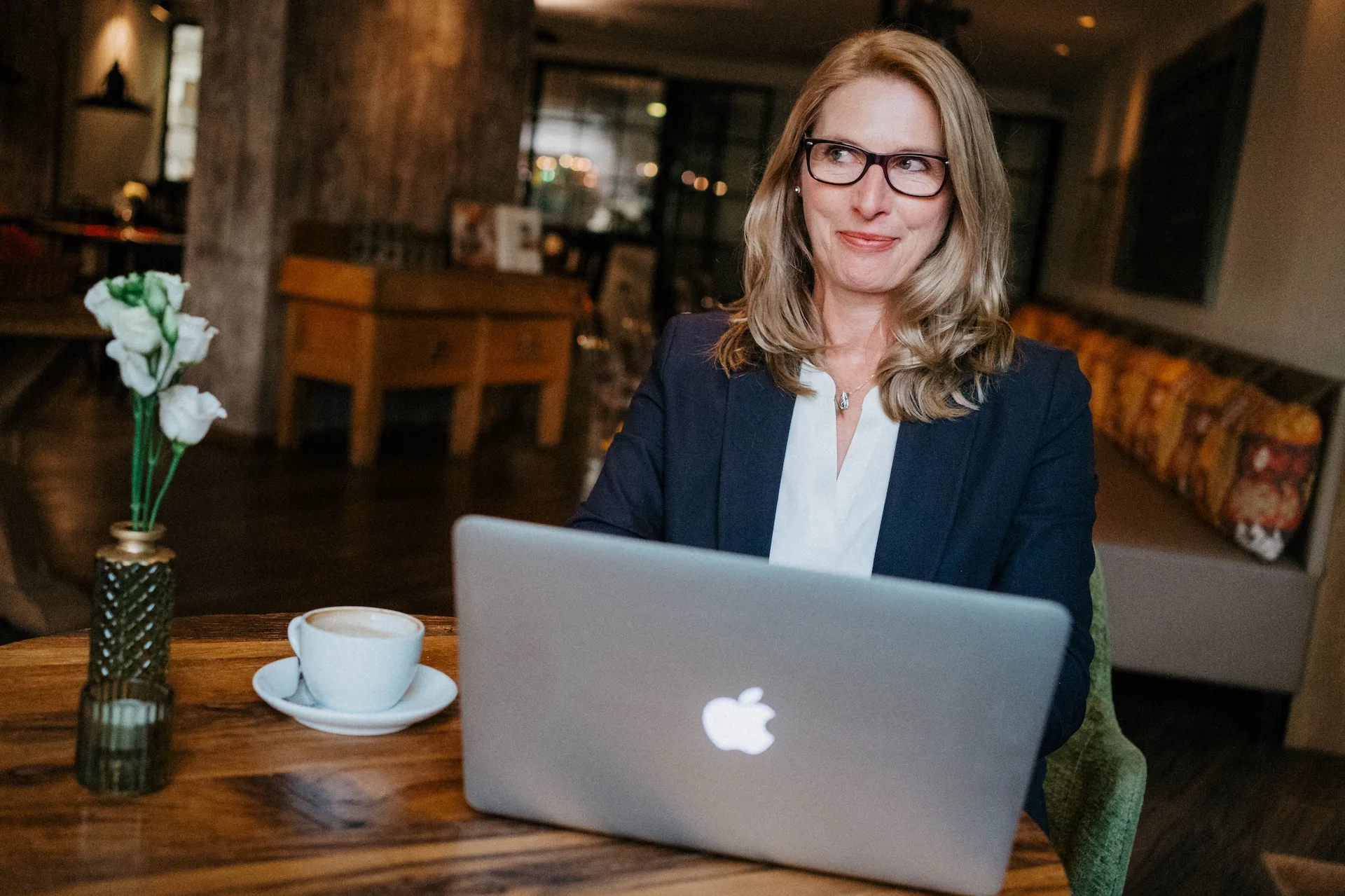 Weibliche Person sitzt im Café vor einem Laptop